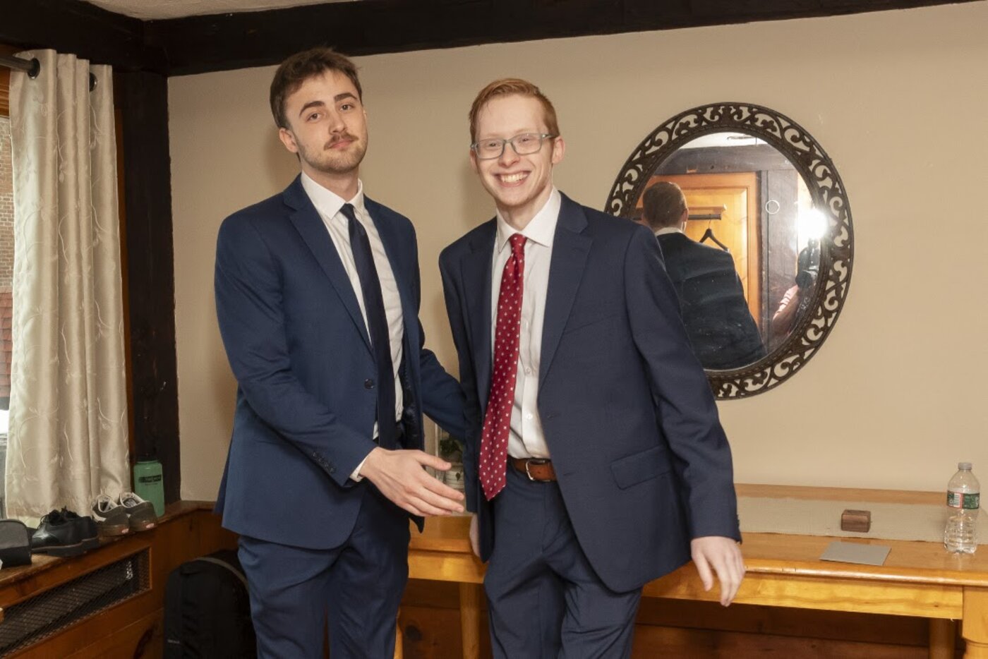 The two founders shaking hands in front of a mirror